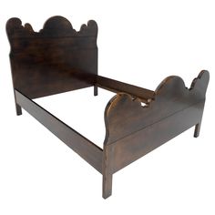 a wooden bed frame with an intricate headboard and foot board