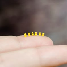 small yellow rubber ducks sitting on top of someone's finger