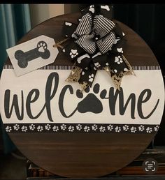 a welcome sign with a dog's paw and bone on it, sitting on top of a table