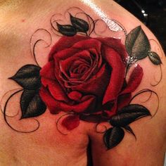 a rose tattoo on the back of a woman's left shoulder and chest area