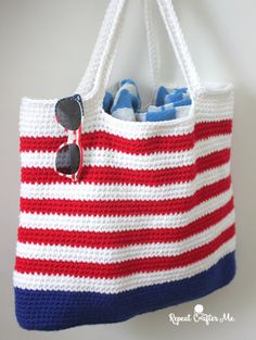 a red, white and blue crocheted bag with sunglasses on it's handle