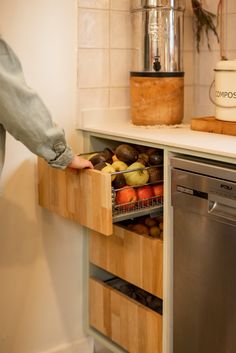 a person is opening the drawers in a kitchen