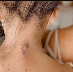 a woman with a small tattoo on her neck