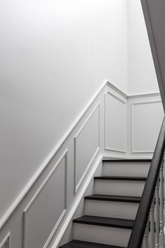 a black and white photo of some stairs in a house or office building with paneling on the walls