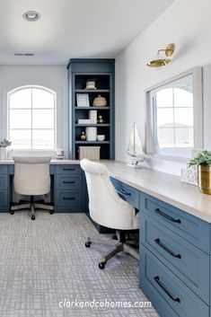 a home office with blue cabinets and white desks in the center, along with an open bookcase