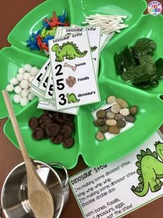 a green tray filled with lots of different types of rocks and plants on top of a table