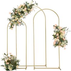 an iron arch with flowers and greenery on the sides, along with two vases