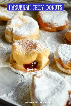 there are many jelly donuts on the baking sheet with powdered sugar sprinkles