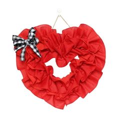 a red heart shaped wreath hanging on a clothes line with a black and white checkered bow