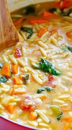 a red pot filled with pasta and vegetables