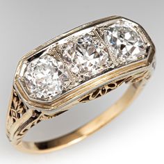 an antique three stone diamond ring with filigrees in yellow gold and white gold