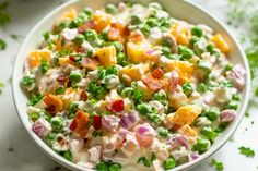 a white bowl filled with peas and fruit salad