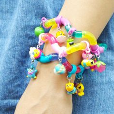 a person wearing a bracelet with lots of charms on their wrist and holding it in the other hand