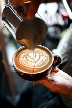 a person pours coffee into a cup