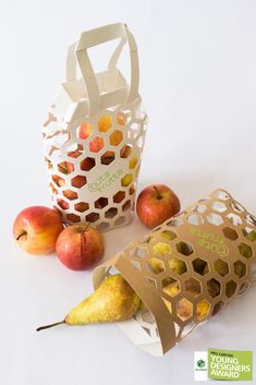 an apple, pears and honeycomb bag sitting next to each other on a white surface