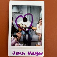 a polaroid with the words john mayer on it and two people playing guitar in front of a heart