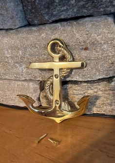 an anchor is sitting on the table next to some screws