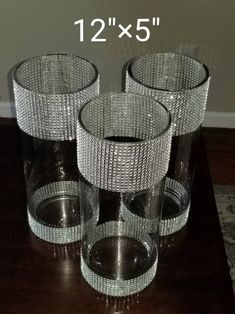 three clear glass vases sitting on top of a wooden table