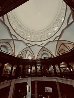 the inside of a large building with high ceilings and arched windows, looking up at the ceiling