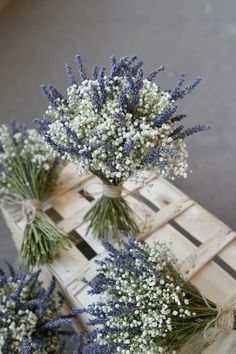 three vases filled with lavender flowers sitting on top of a wooden pallet next to each other