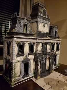 a doll house made out of paper with windows and balconies on the roof