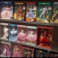 several shelves filled with barbie dolls on display