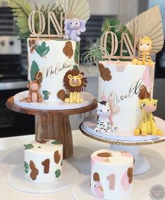 two tiered cakes decorated with animals and jungle decorations on top of each cake stand