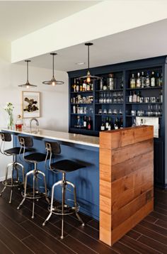 a bar with stools and shelves filled with bottles