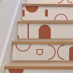 the stairs are painted with orange and white circles on them, as well as wood treads