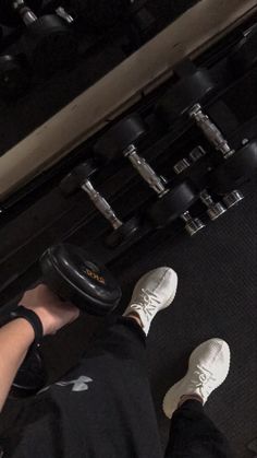 the person is doing exercises with dumbbells in front of an exercise machine at the gym