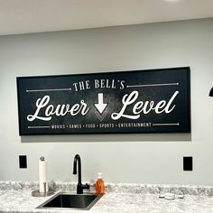 a sign that says the bell's lower level level above a sink in a kitchen