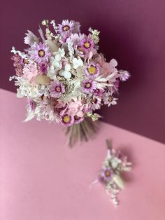 a bouquet of flowers sitting on top of a pink surface