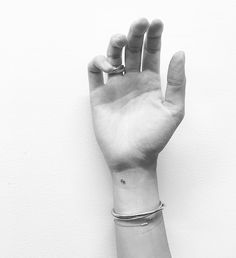 black and white photograph of a person's hand with a ring on their wrist