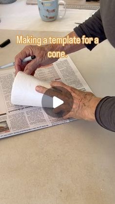 an old man is making a newspaper on the table