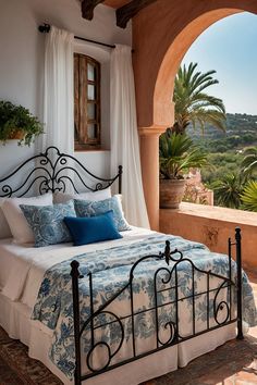 a bed sitting under a window next to a lush green hillside covered in palm trees