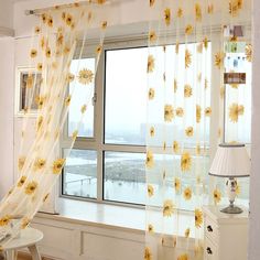 a window with yellow flowers on the curtains