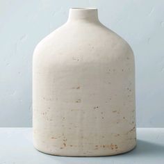 a white vase sitting on top of a table