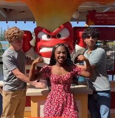 two boys and a girl standing in front of a mascot