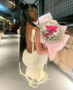 a woman with long hair holding a bouquet of flowers