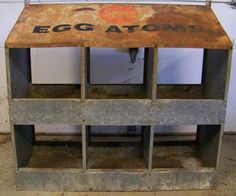 an old metal shelf with eggs atomb written on the top and bottom, in front of a white wall