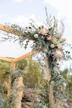 an outdoor wedding ceremony with flowers and greenery