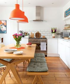 a kitchen with an oven, stove and dining room table in it's center