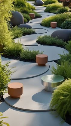 an outdoor garden area with circular planters and plants on the ground, surrounded by grass