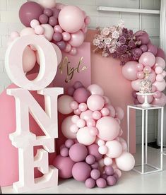 pink and white balloons are arranged in the shape of letters that spell out one love