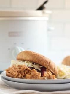 a chicken sandwich on a plate next to an instant pot