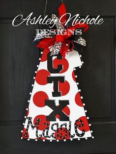 a door hanger that has the letter x on it and is decorated with polka dots