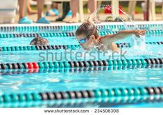 people are swimming in the pool with their hands up and one person is jumping into the water