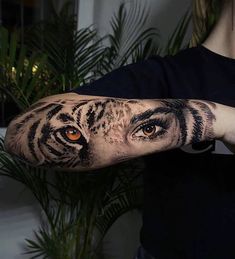 a man with a tiger eye tattoo on his arm