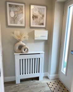 a white radiator sitting next to two pictures on the wall