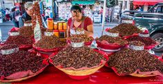 a woman standing in front of a table filled with lots of different kinds of food